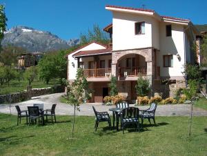 una mesa y sillas frente a una casa en Apartamentos Javier en Turieno