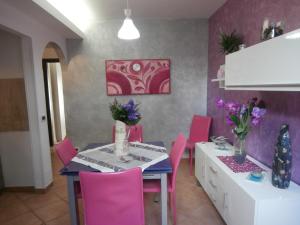 a dining room with a table and pink chairs at Busalacchi B&B in Mondello