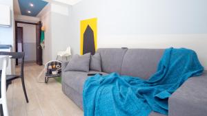 salon z kanapą i kocem w obiekcie Babyaccommodation Family Experience II w mieście Pietra Ligure