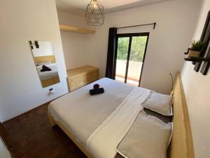 a bedroom with a bed with a black box on it at Algarve Surf Hostel - Sagres in Sagres