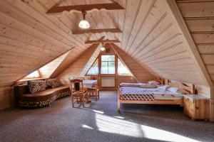 - une chambre dans une cabane en rondins avec un lit et un canapé dans l'établissement Galicówka Pokoje Gościnne, à Małe Ciche