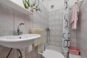 a white bathroom with a sink and a toilet at Dado A4 Studio Apartments in Igrane