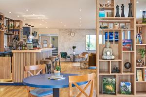 une chambre avec une table, des chaises et un bar dans l'établissement Kyriad Paris Sud Les Ulis Courtaboeuf, aux Ulis