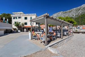 a group of people sitting at a table under a pavilion at Dado A4 Studio Apartments in Igrane +24 photos