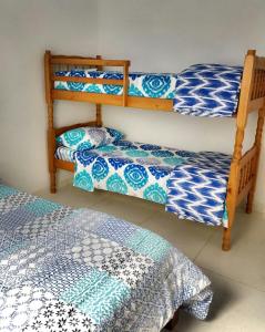 1 dormitorio con 2 literas con sábanas azules y blancas en Recanto da Nice en Paraty