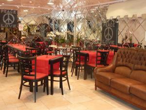 a restaurant with tables and chairs and a couch at Hôtel Villa Boeri in Beausoleil