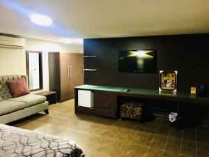 um quarto de hotel com uma cama e um sofá em BW Starfire Hotel em Ikeja