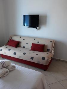 a bedroom with a couch and a tv on the wall at Studio avec piscine Cabo Dream à Cabo négro in Cabo Negro