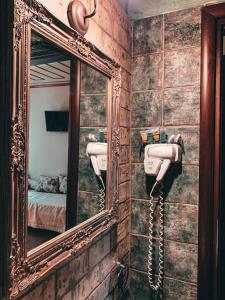 - un miroir et un téléphone dans la salle de bains pourvue d'un lavabo dans l'établissement Elena Guesthouse, à Kalambaka