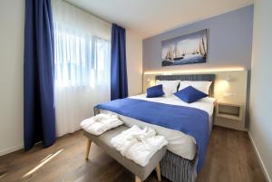 a bedroom with a blue and white bed with towels on a bench at Villa Lungomare in Malinska