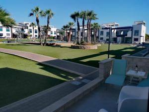 a view of a park with palm trees and buildings at Bright bungalow Oasis Beach La Zenia in Orihuela
