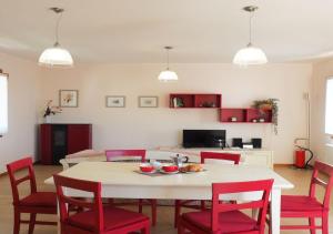 sala de estar con mesa y sillas rojas en Albergo Diffuso Polcenigo C.Barnard, en Polcenigo