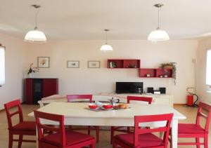 uma sala de estar com uma mesa e cadeiras vermelhas em Albergo Diffuso Polcenigo C.Barnard em Polcenigo