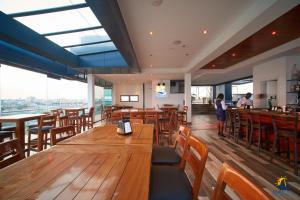 a restaurant with wooden tables and chairs and windows at Suncity Hotel Apartment in Accra