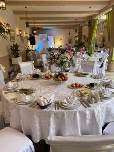 a long white table with plates of food on it at Centre Hostel in Mukacheve