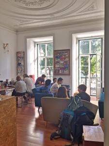 
people sitting in a living room with laptops at Lookout Lisbon Hostel in Lisbon
