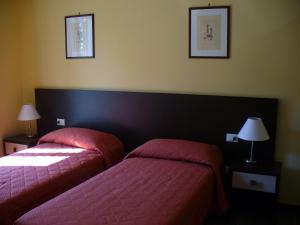 - 2 lits dans une chambre d'hôtel avec des draps roses dans l'établissement Appartamento IL POGGIO, à Tortoreto Alto