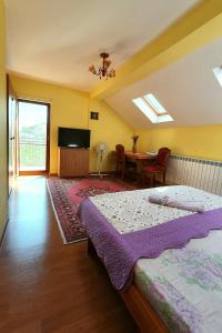 a bedroom with a bed and a table and a television at Vila Granada in Eforie Nord