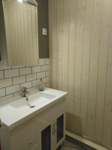 a bathroom with a white sink and a mirror at Tohninmäen Talo in Töysä