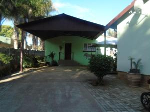 a house with a black roof and a driveway at Marnalé Oornagwoonstel in Piet Retief