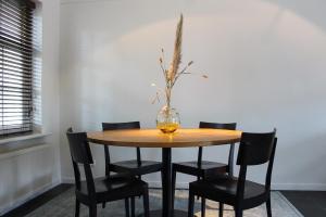 a dining room table with a vase on top of it at Casa Vinke op Ameland in Hollum