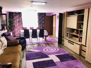 - un salon avec une table et un tapis violet dans l'établissement Casa de la Lac, à Sighetu Marmaţiei