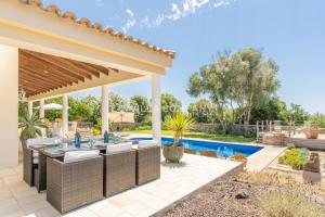 un patio trasero con piscina y pérgola en Villa Mala Bay en Mahón