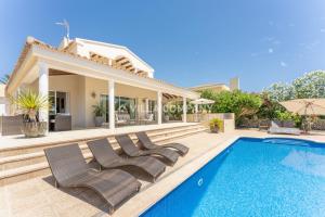 een villa met een zwembad en een huis bij Villa Mala Bay in Mahón