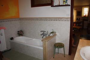a bathroom with a tub and a sink and a stool at B&B MAMMA ARI in Fermo
