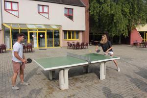 a man and a woman playing a game of ping pong at Auberge de Jeunesse HI Strasbourg 2 Rives in Strasbourg