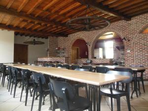a long table and chairs in a room with a brick wall at Hof Ten Beemd in Oudenaarde