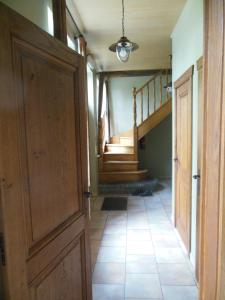 a hallway with a door and stairs in a house at Hof Ten Beemd in Oudenaarde