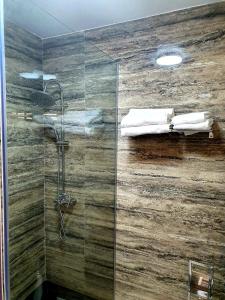 uma casa de banho com um chuveiro e uma parede de vidro em Hotel Restaurant Elite em Drobeta-Turnu Severin
