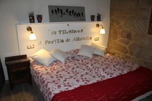 a bedroom with a bed with a red comforter at Apartamento Rural "Os Telesforos" in Allariz