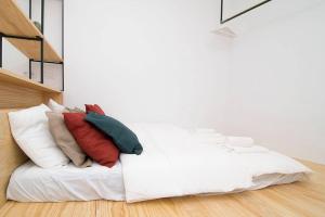 un letto bianco con cuscini sopra in una stanza di Loft de Diseño en Pleno Centro de Madrid, Calle Torrecilla del Leal, by Batuecas a Madrid