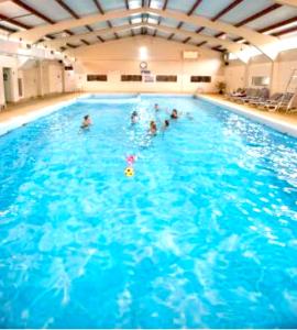 un grupo de personas en una gran piscina en Clifftop Chalet With Pool en Deal