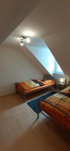 a attic room with two beds and a window at Ferienwohnung Viktoria in Bad Bertrich