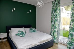 - une chambre dotée d'un lit avec un mur vert dans l'établissement Chill&Sun Green, à Łukęcin