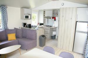 een woonkamer met een bank en een keuken bij MOBIL HOME 6/8 places in Onzain