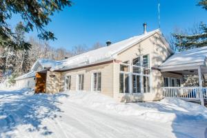 a house is covered in snow in front of it at Chalets Lanaudière in Rawdon +33 photos