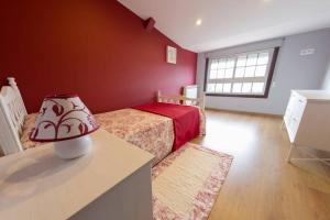 a bedroom with a bed and a table with a lamp at Casamary Buhardilla in Pontevedra