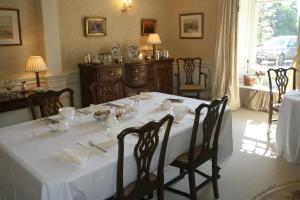 uma sala de jantar com uma mesa branca e cadeiras em Kirklands House Melrose Bed and Breakfast em Melrose