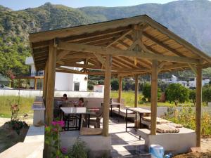 a wooden pavilion with people sitting at tables in a garden at EVALiN in Mugla