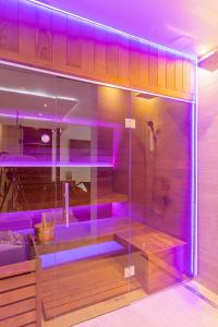 La salle de bains est pourvue d'une douche avec un éclairage violet. dans l'établissement #1 Luxury Villa with Pool, Gameroom, Spa, Zen Yard, à Belgrade