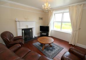 a living room with a couch and a coffee table at Alcorn's Farmhouse in Rathmullan
