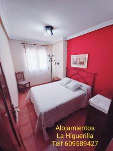 BurunchelにあるAlojamientos Rurales La Higuerilla Sierra de Cazorlaの白いベッドと赤い壁が備わるベッドルーム1室が備わります。