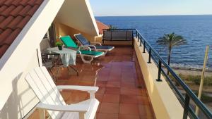 a balcony with chairs and a table and the ocean at Penthouse Marina Sol in Madalena do Mar