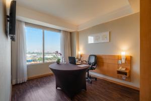 グアルーリョスにあるMercure Guarulhos Aeroportoのデスクと窓のあるオフィス