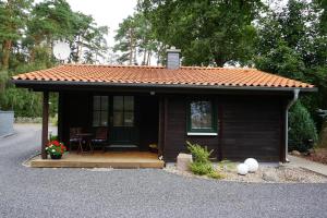 a small house with a roof on a driveway at Ferienhaus Schneeberger in Winsen Aller