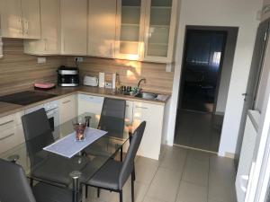 małą kuchnię ze szklanym stołem i krzesłami w obiekcie Classic City Apartman w Segedynie